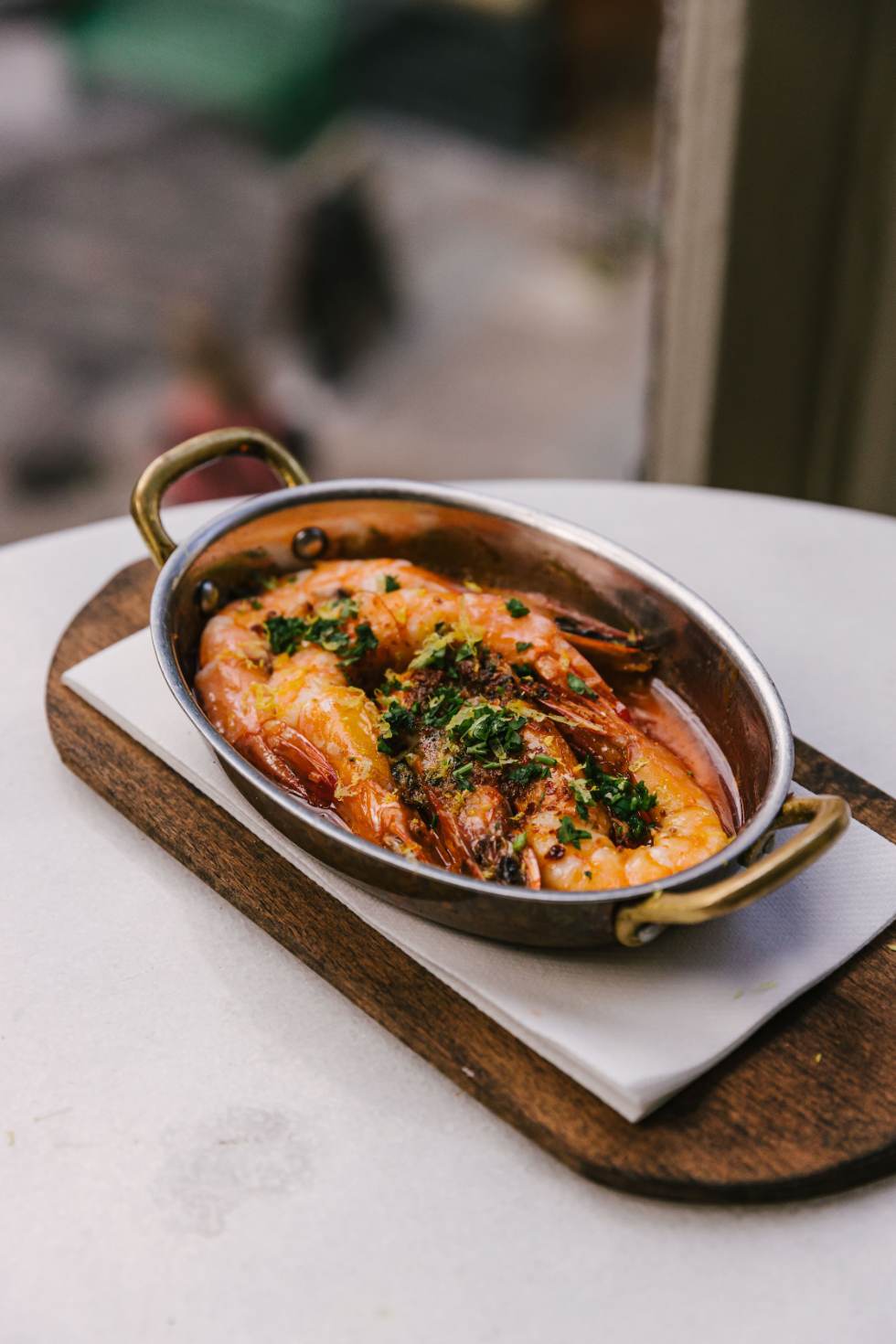 Wood-fired prawns in a copper pan